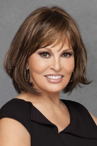 Woman in shoulder length brunette wig with light brown highlights and bangs